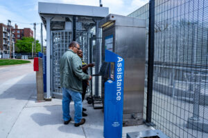 Customer and Transit Security Specialist look at Ticket Vending Machine together near MetroLink security gates